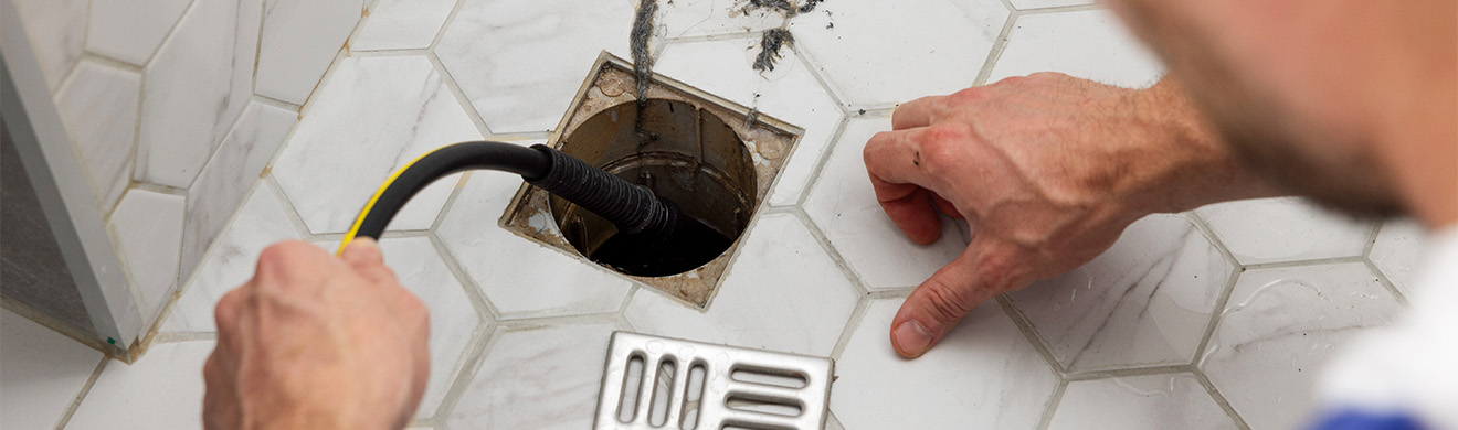 Klempner reinigt verstopften Duschabfluss mit Hochdrucktechnik im Badezimmer in Offenbach und beseitigt hartnäckige Ablagerungen zuverlässig